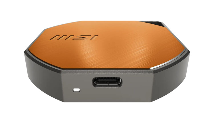 MSI device with an orange brushed-metal top and a USB-C port on the front edge.